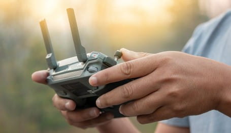 Drone user holding a controller for a compact drone